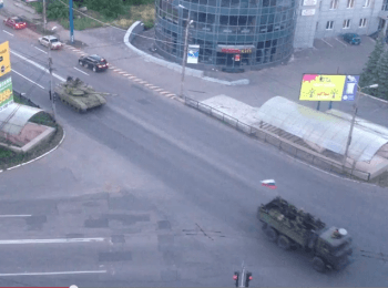 Column of tanks and armored cars under the Russian flag in the center of Makiyivka, on June 12, 2014