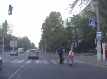 Odessa policeman helps the the woman to cross the street